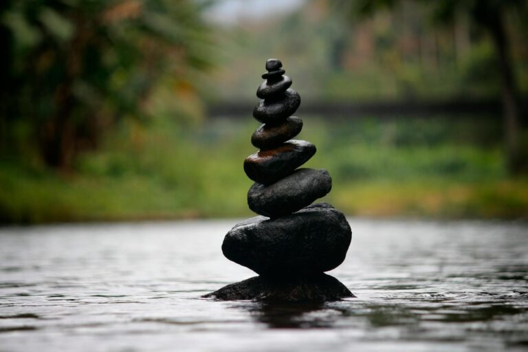 Balanced stones in a serene river evoke a sense of peace and tranquility.